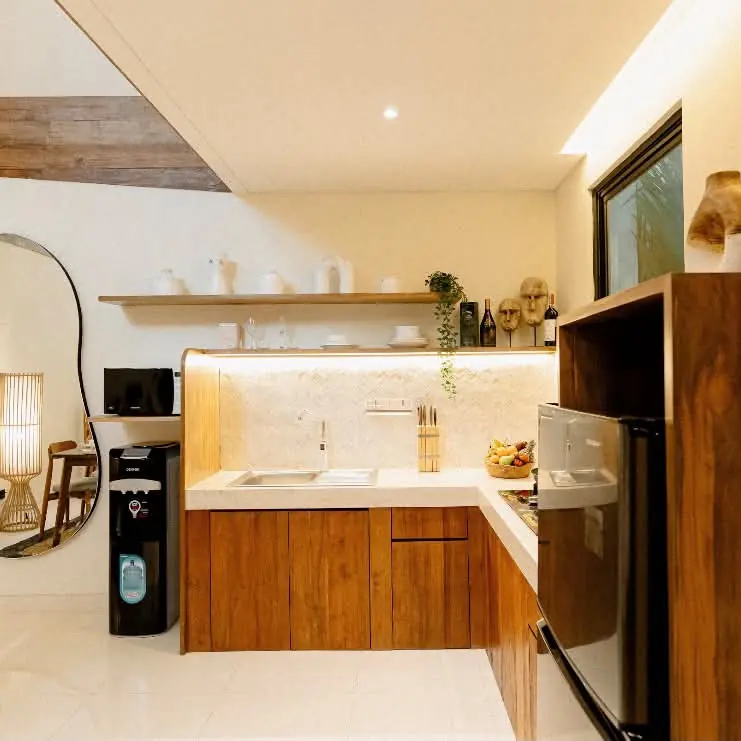 Open kitchen with teak cabinets and a round mirror in a furnished villa
