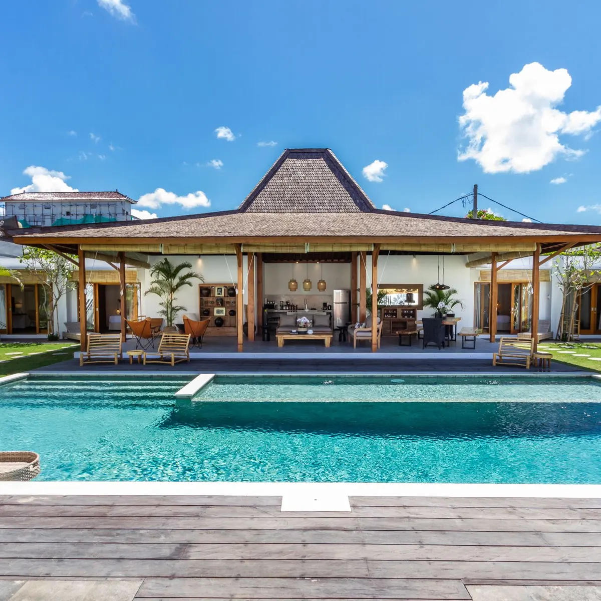 Villa with a traditional pitched roof behind a long swimming pool