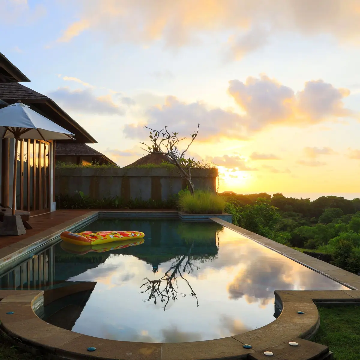 Villa pool reflecting the sky at sunset